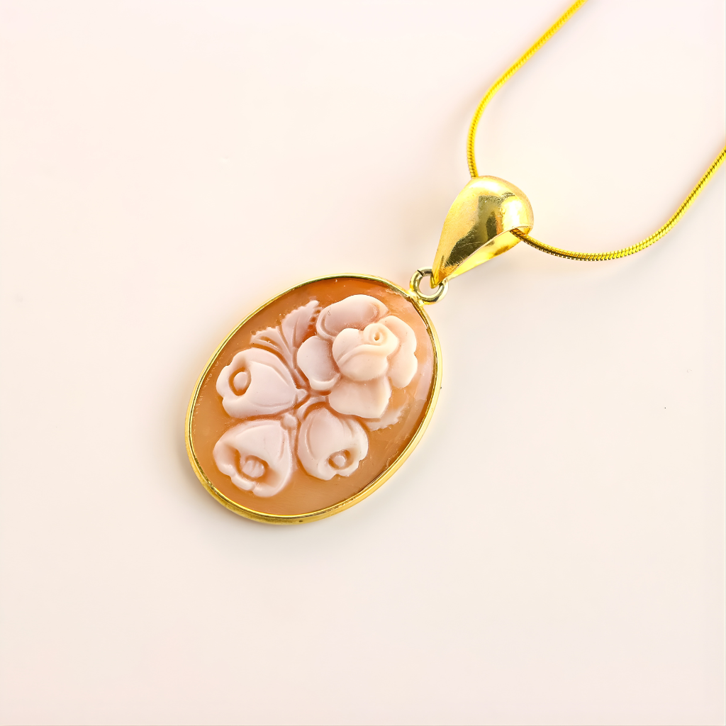 Gold flower necklace with floral cameo design on a white background