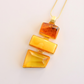 statement Necklace with orange and yellow pendant on a light background