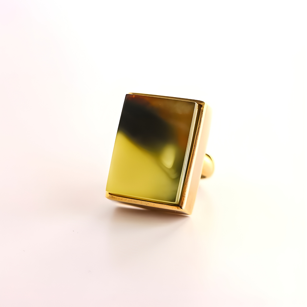 Gold amber ring with a yellow gemstone on a white background