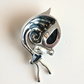A sterling silver amber snail pendant resembling a stylized snail with a large dark inlay, photographed on a plain off-white background.