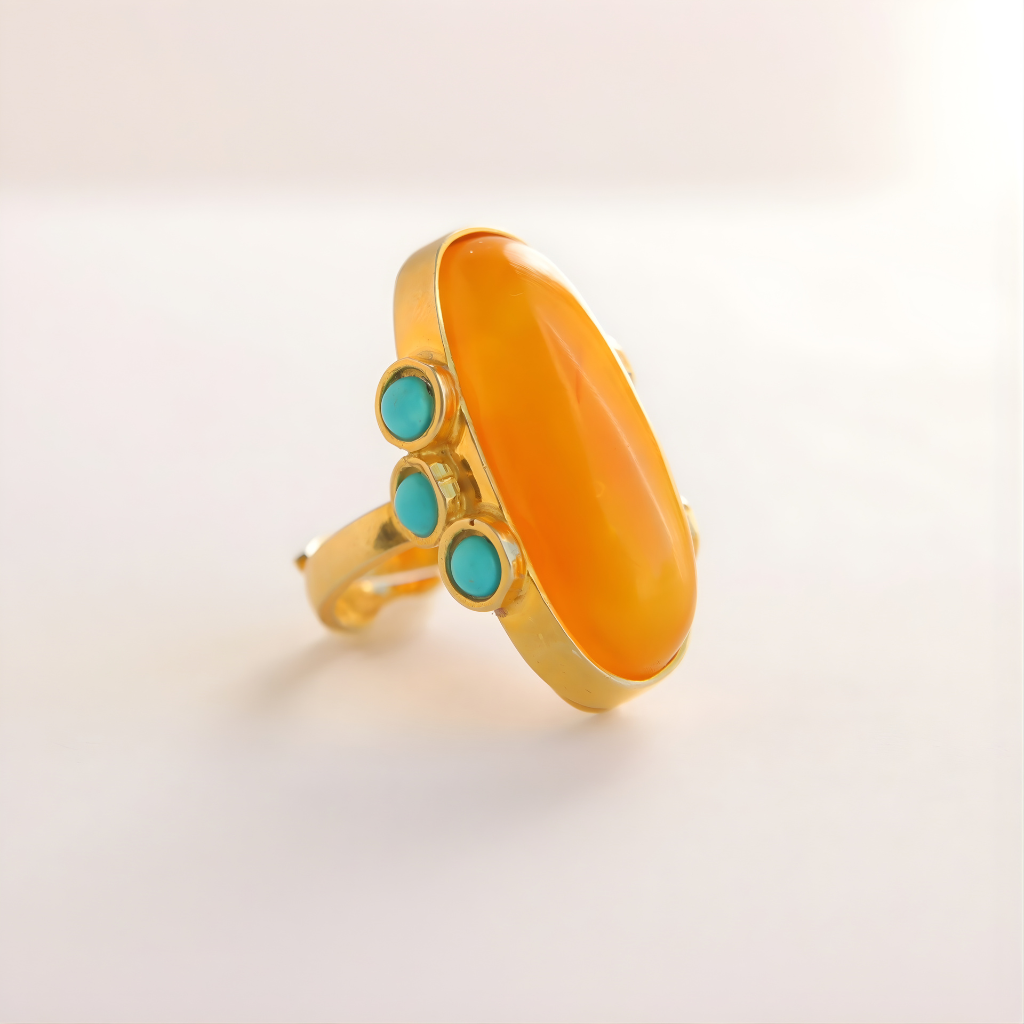 Gold amber ring with orange stone and turquoise stones on a light gray background