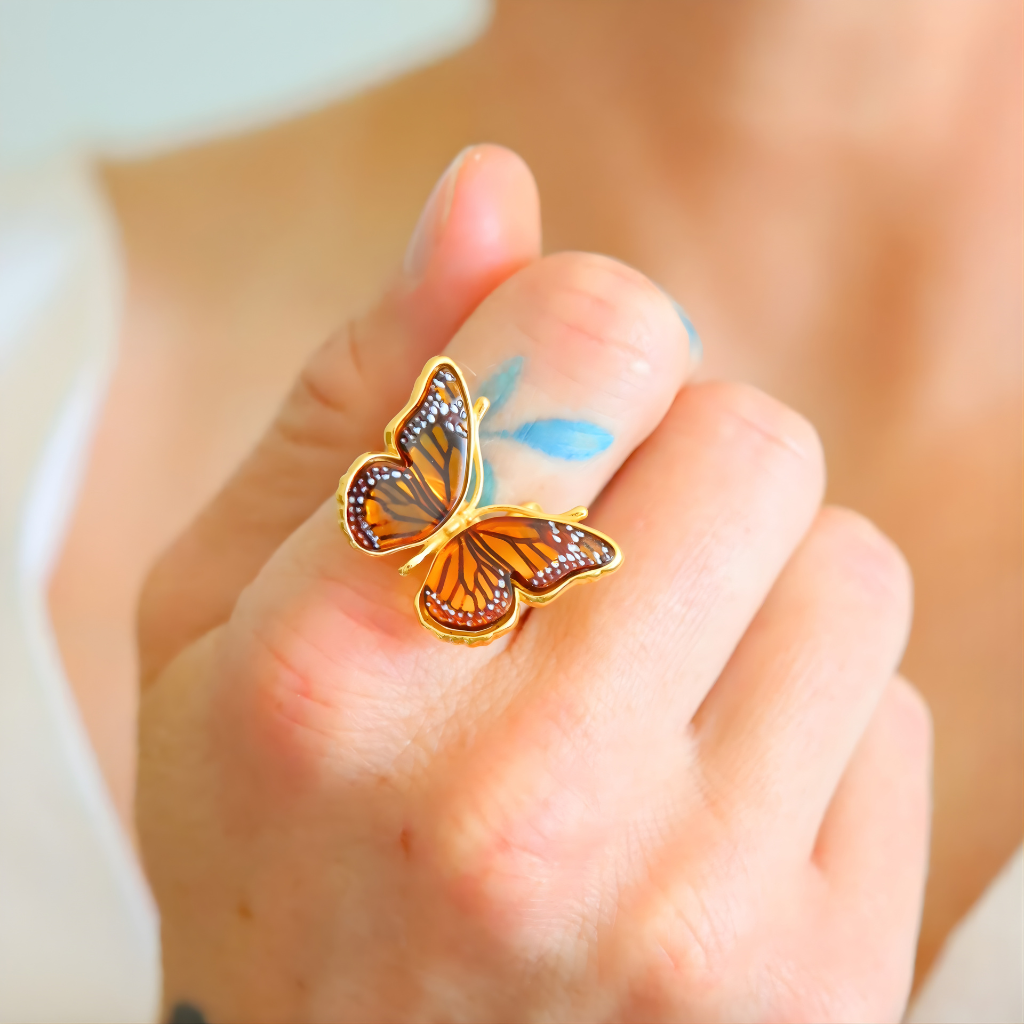 Butterfly ring on a person's finger with a blurred background