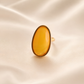 amber Ring with a yellow gemstone on a beige fabric background
