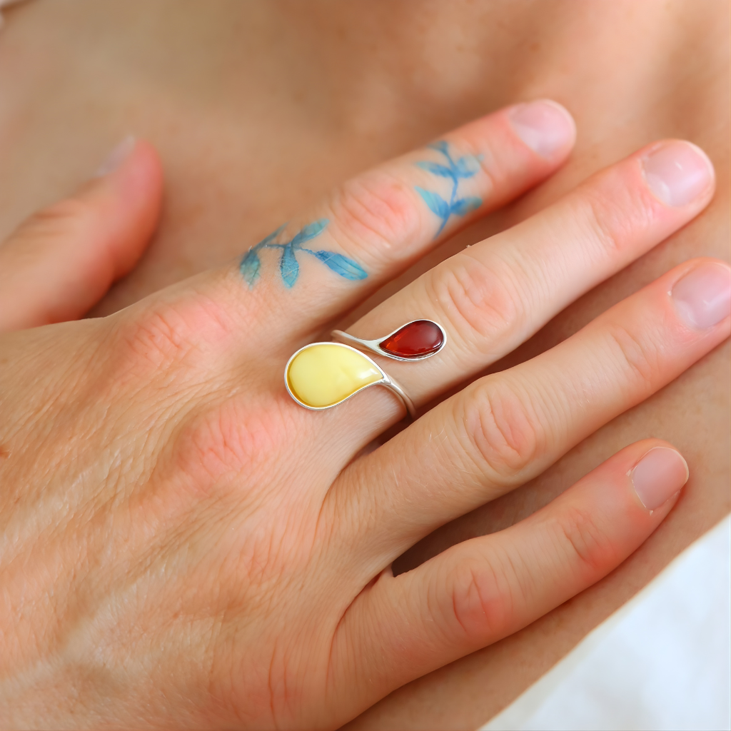 Close-up of a hand wearing a colorful sterling silver ring with water droplet design.