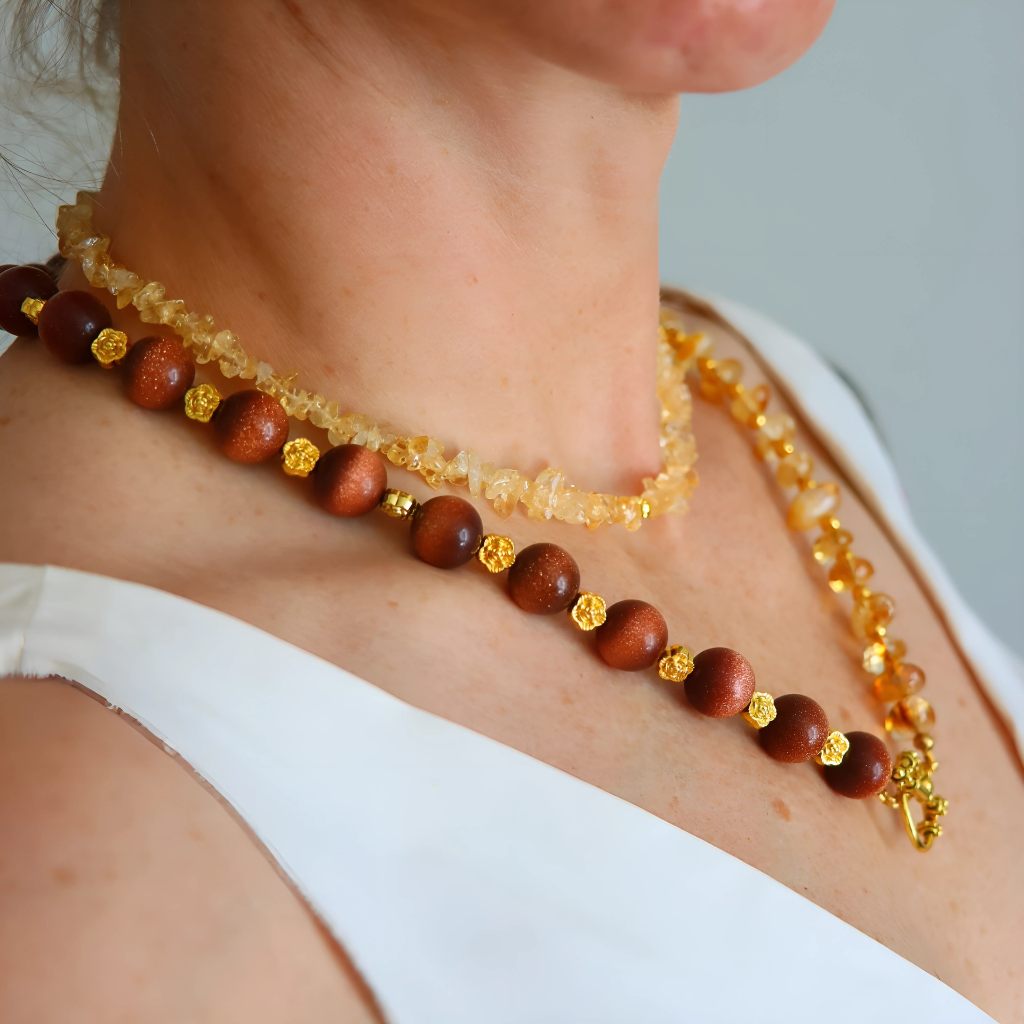 Handmade layered necklace with goldstone and citrine, gold plated beads, gold flower accents, choker and long strand design by Alexis Cintron.