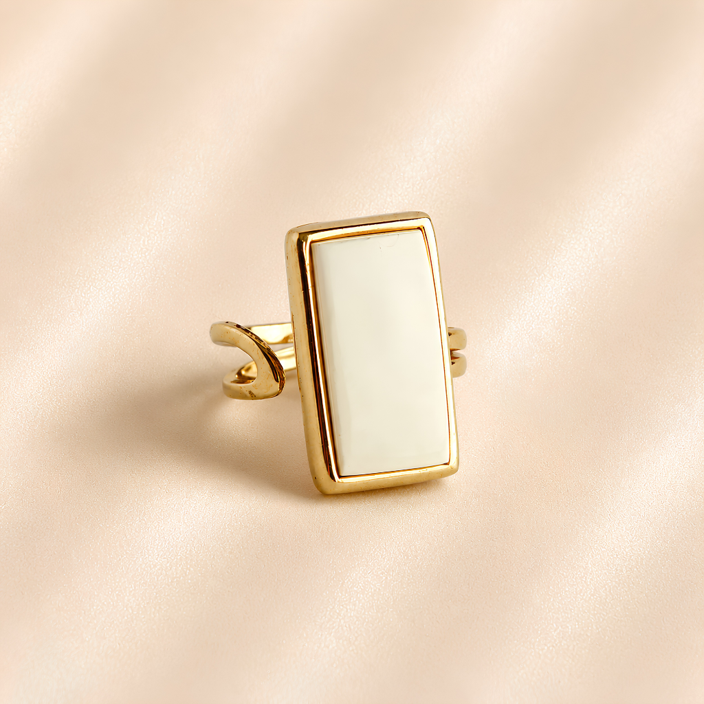 Angled view of white amber ring showing rectangular stone, gold-tone setting, and open band.