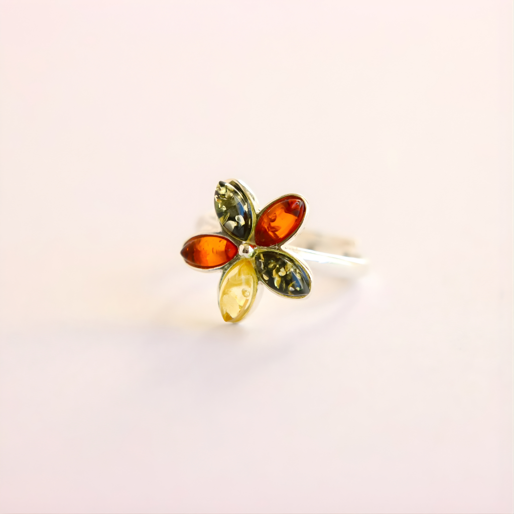 Multicolored gemstone amber ring on a light pink background