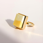 Gold square amber ring on a light gray background