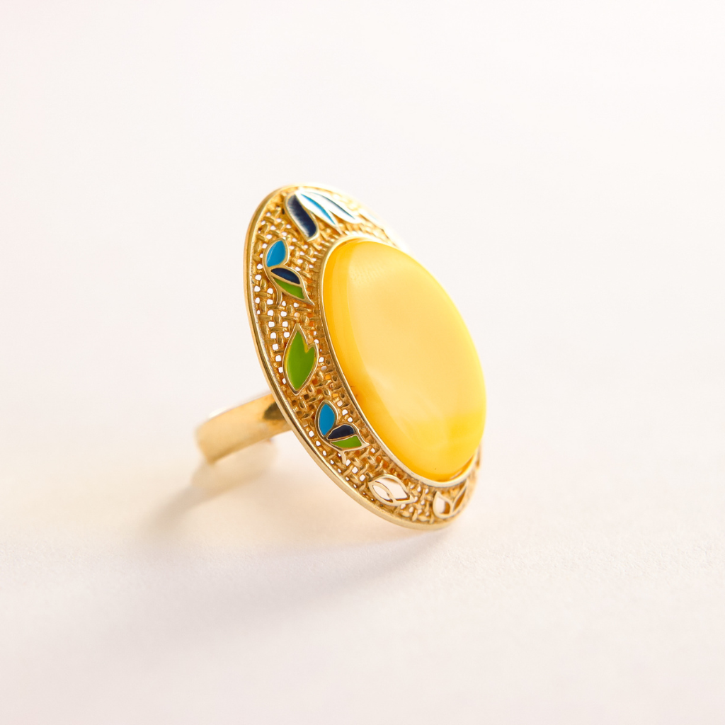 Gold butterscotch amber ring with a yellow gemstone on a light background