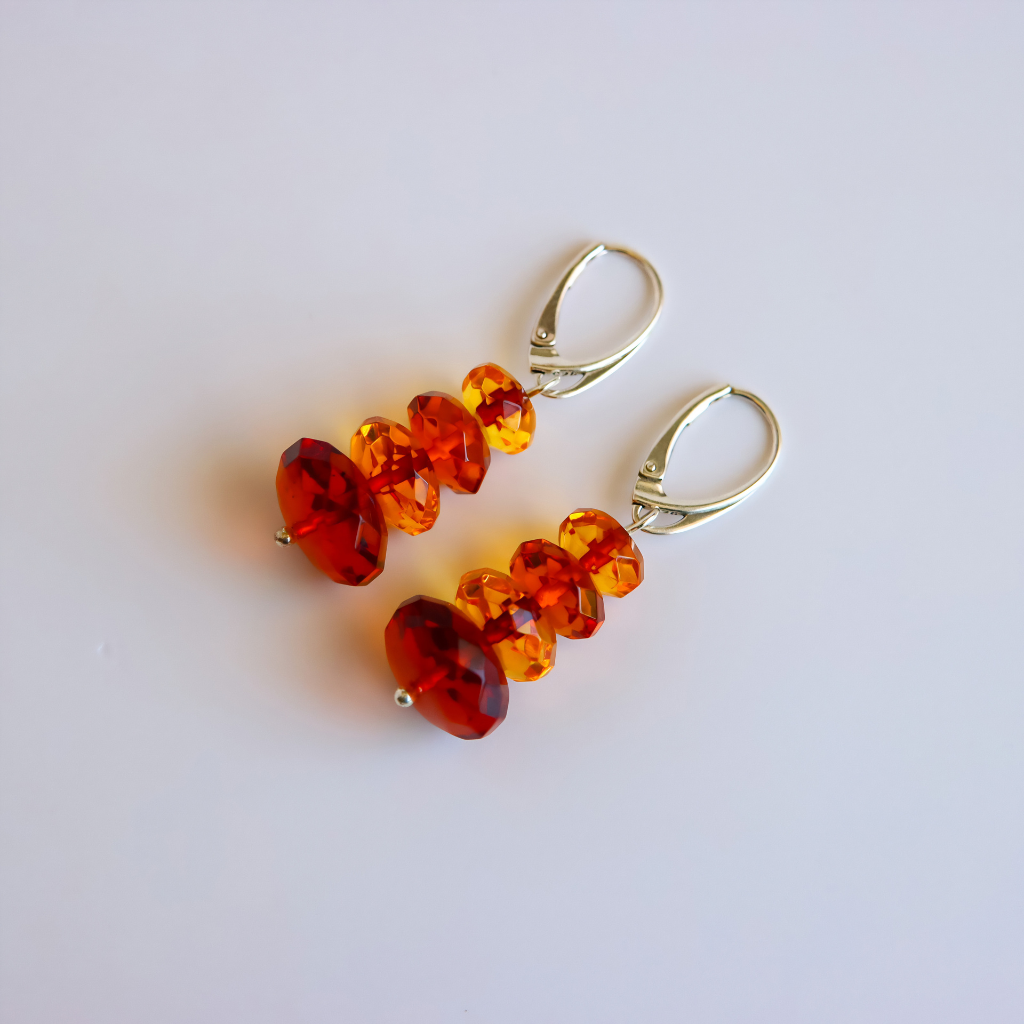orange and red amber drop earrings on white background