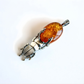 Amber pendant with silver beetle design on a white background