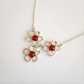 amber flower necklace with red gemstones on a white background