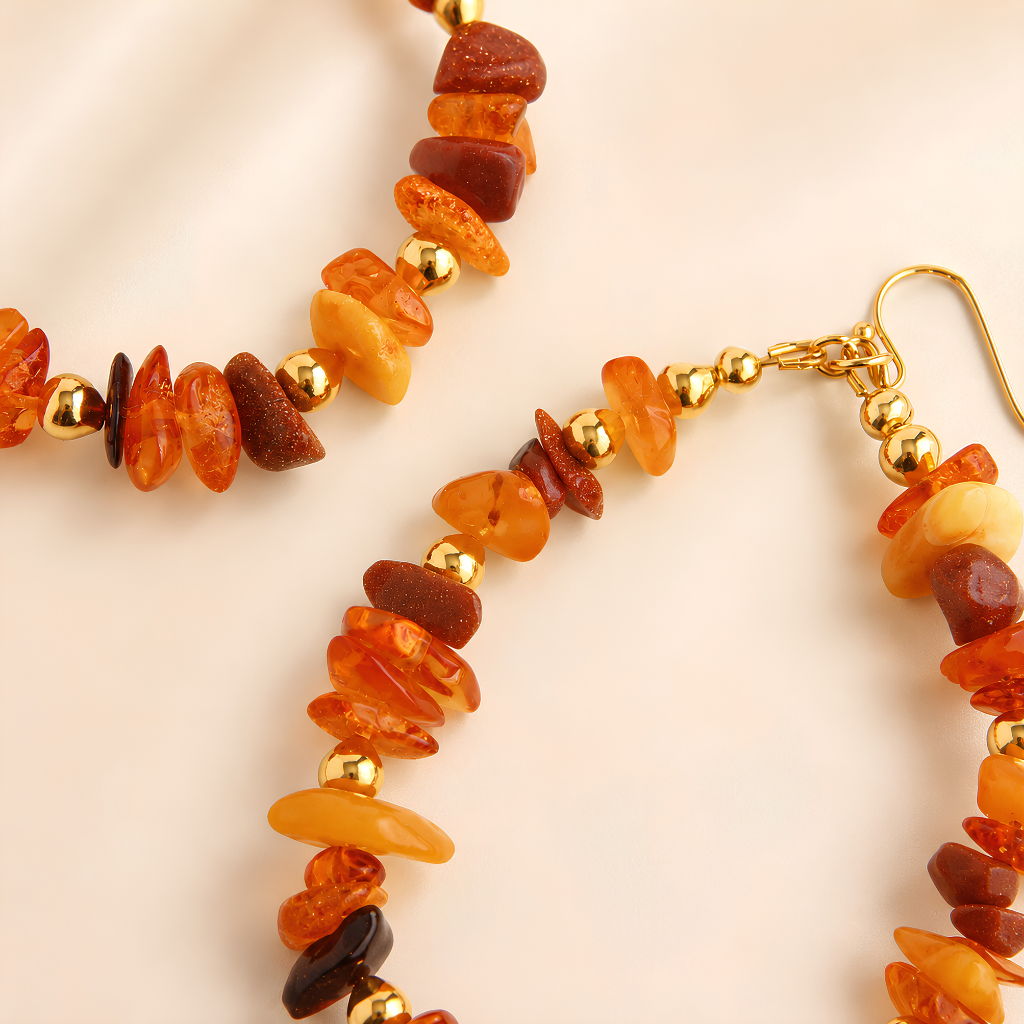 Baltic amber earrings with amber beads and gold accents on a beige background