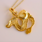 Gold dragon pendant on a chain against a light background