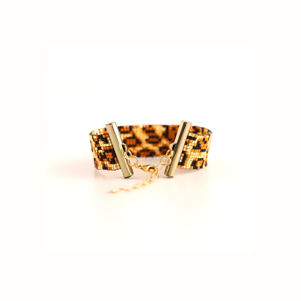 Leopard print beaded bracelet with gold clasp on a white background