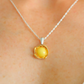 Yellow pendant necklace on a person's neck