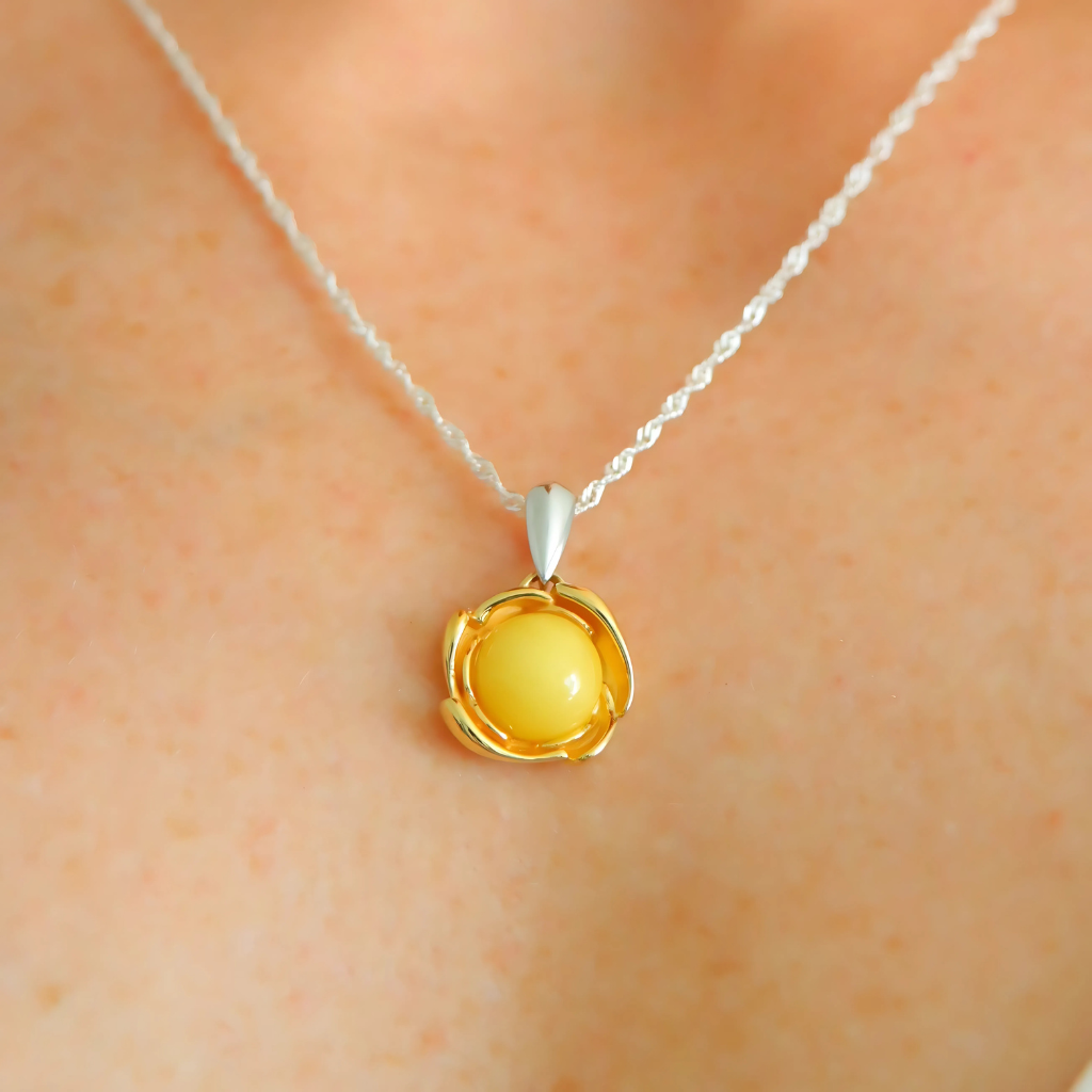 Yellow pendant necklace on a person's neck