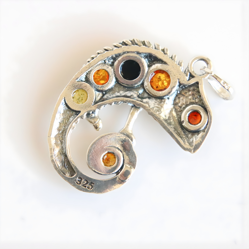 Silver amber pendant with colored stones on a white background