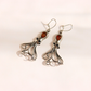 A pair of silver-toned dangle amber octopus earrings with intricate curled tentacle-like wire details and oval amber-colored stone accents, photographed on a plain light background.