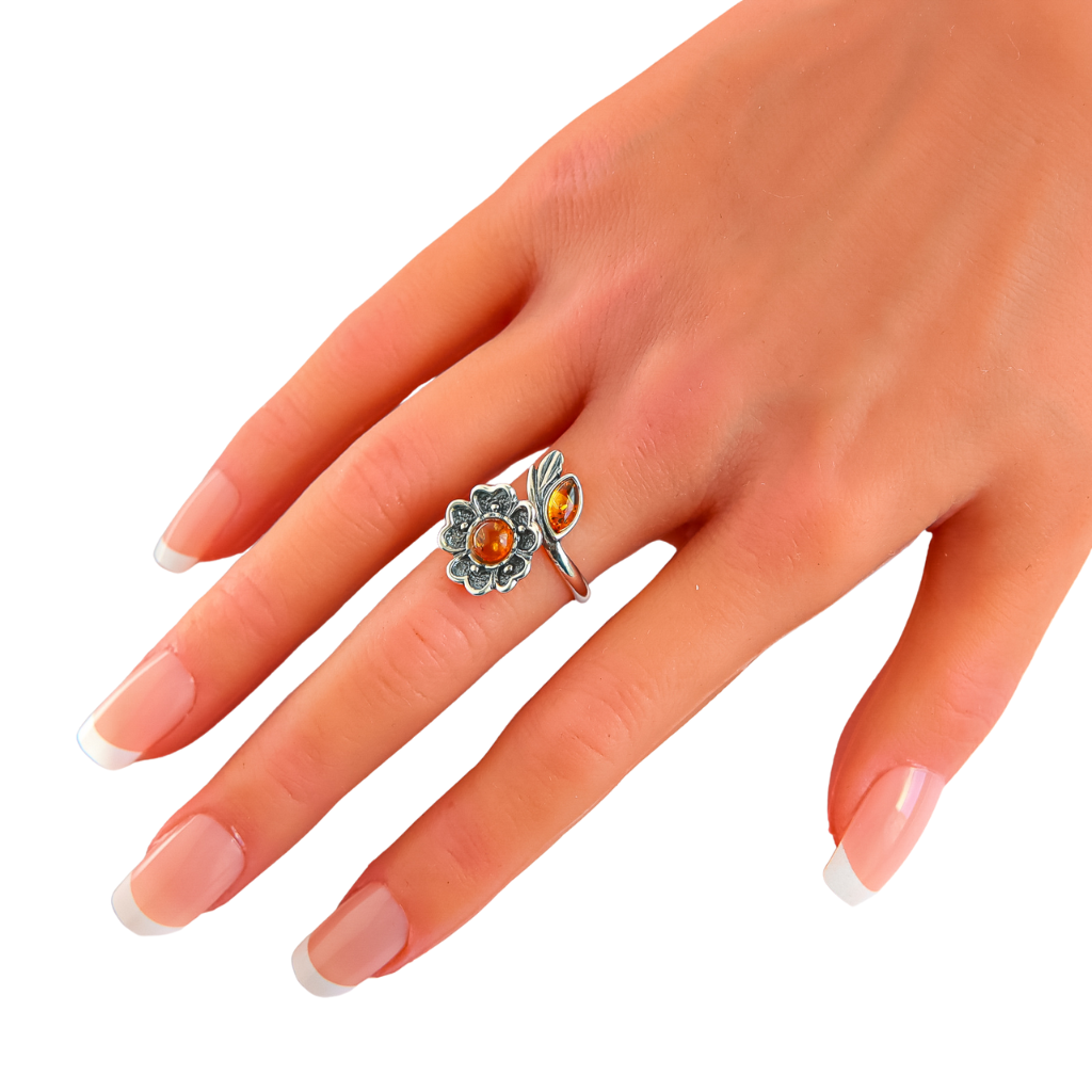 Natural Baltic Cognac Amber adjustable flower ring on a hand, featuring a vintage-inspired 925 sterling silver band.
