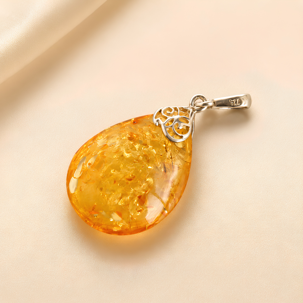 Teardrop-shaped amber pendant on a beige background
