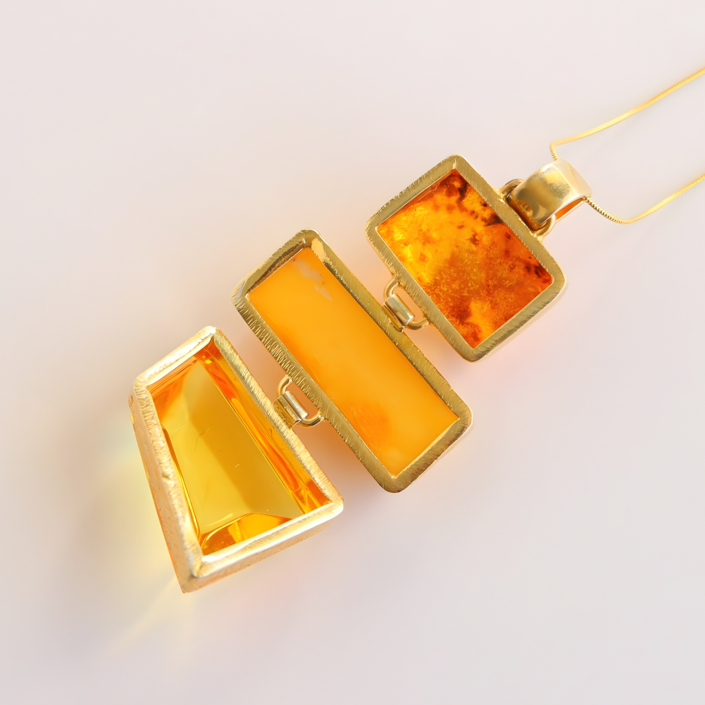 Gold-framed amber-colored rectangular statement necklace on a light background