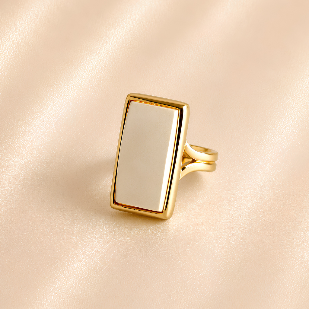 White amber ring with rectangular cream amber stone and polished gold-tone split band.