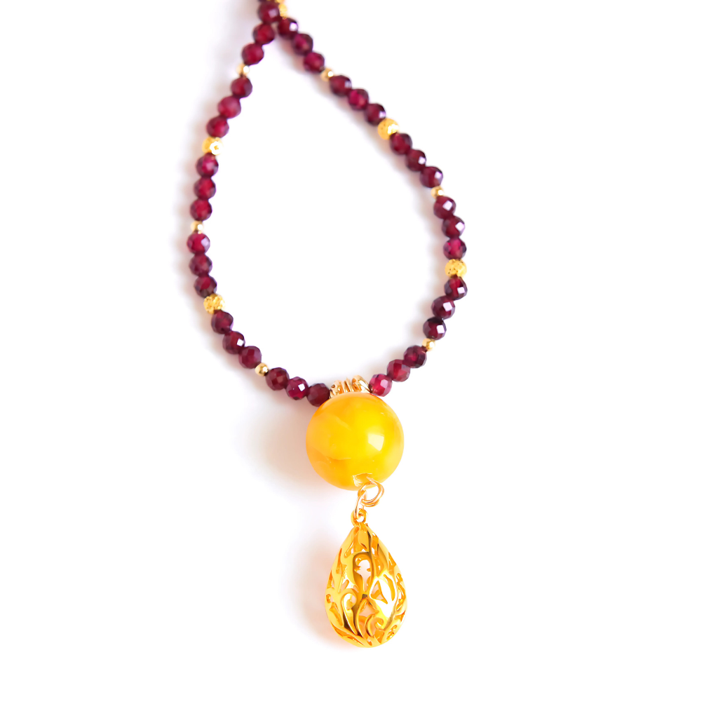 Detailed view of 14k gold-filled butterscotch amber necklace with pendant and garnet strand