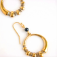 Gold hoop earrings with beaded detailing on a white background