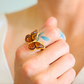 Butterfly ring on a person's finger with a blurred background