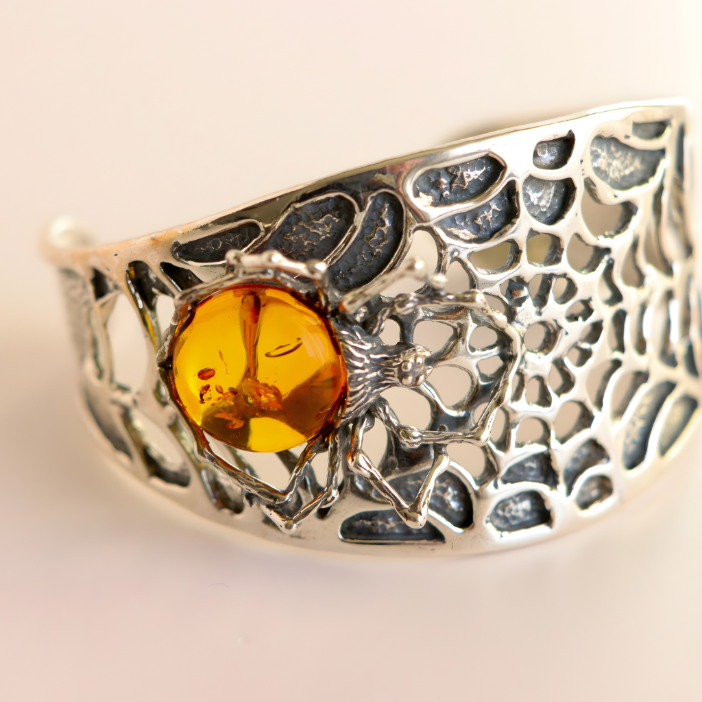 Silver amber bracelet with a central cognac amber stone on a light background