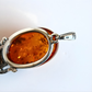 Amber pendant with silver frame on a white background