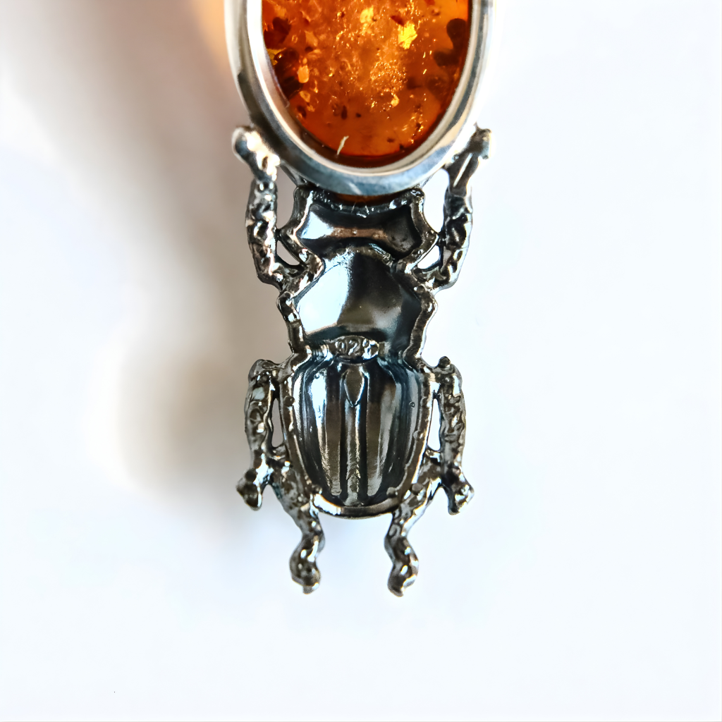 Silver beetle amber pendant on a white background