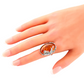 Natural Baltic cognac amber grape leaf statement ring in sterling silver on hand.