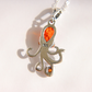 A amber sterling silver octopus pendant necklace featuring a teardrop-shaped orange gemstone on the main body and a small orange stone on one of the tentacles, shown on a white background with a soft shadow.