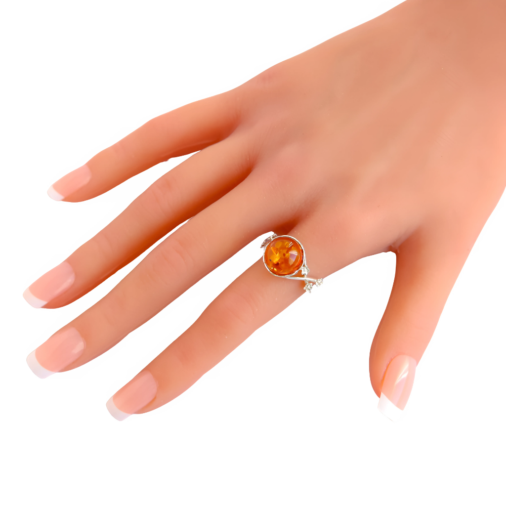 Baltic Cognac Amber ring with silver floral accents on a hand.