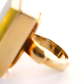 Gold amber ring with a textured band on a white background