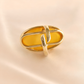 Gold amber ring with amber stone on a beige background
