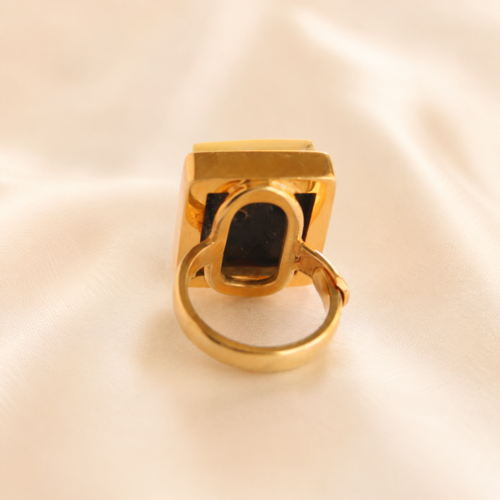 Gold amber ring with a unique design on a beige background