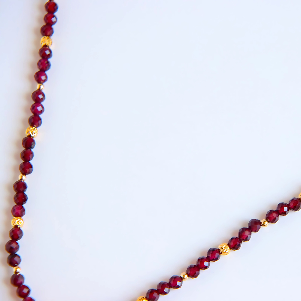 Detailed view of 14k gold-filled butterscotch amber Necklace and garnet strand