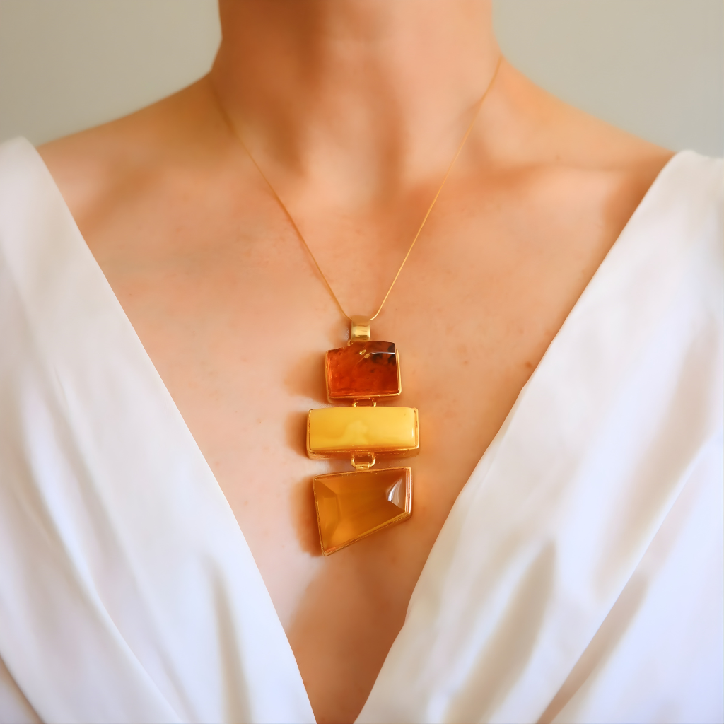 Statement Necklace with amber-colored pendant on a person wearing a white garment