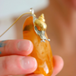 Gold and silver snail-shaped pendant statement necklace on a blurred background