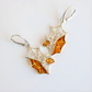 Silver and amber spider web amber earrings on a white background