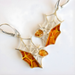 Silver amber earrings with amber-colored stones on a white background