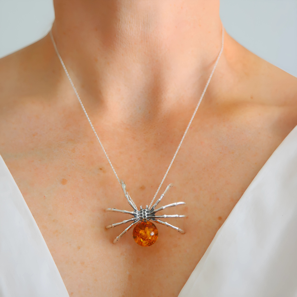 Spider-shaped pendant amber necklace, worn by a person.