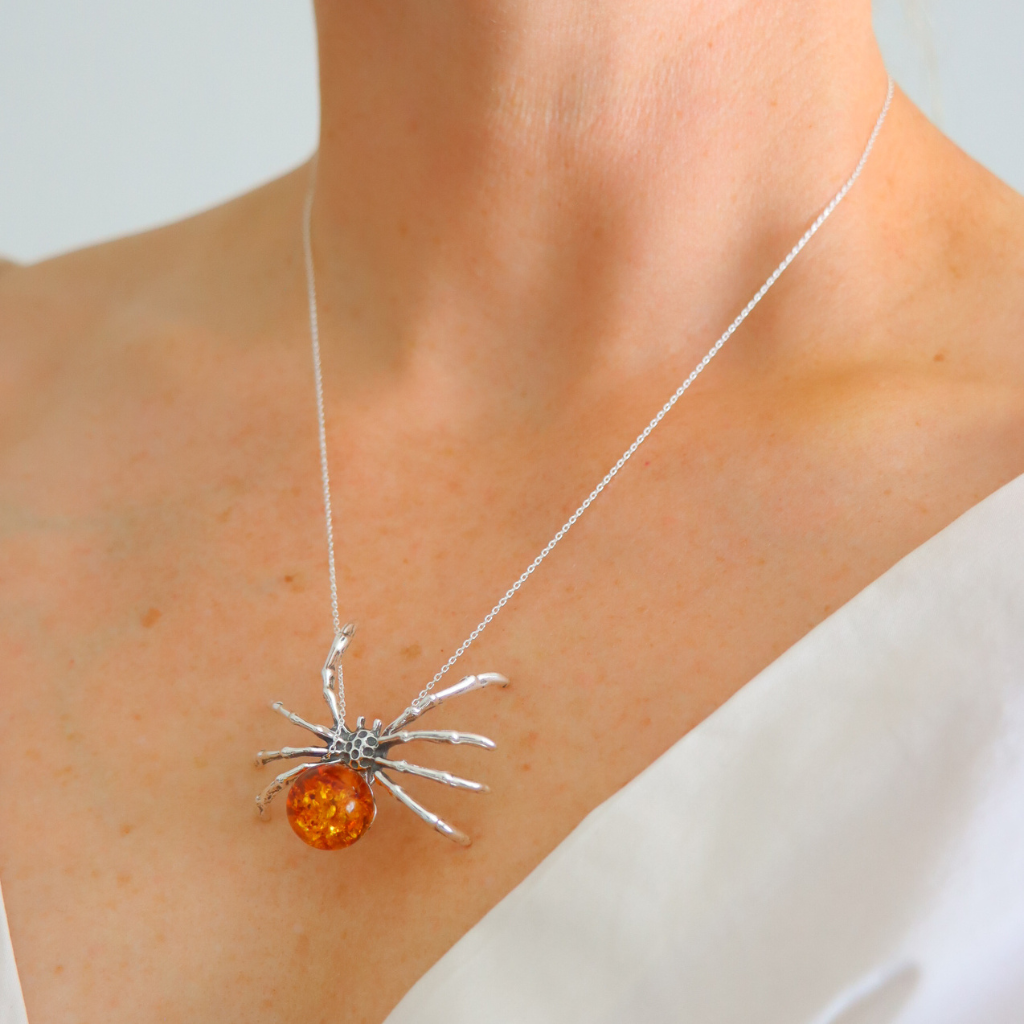 amber necklace with Baltic amber spider pendant worn by person.