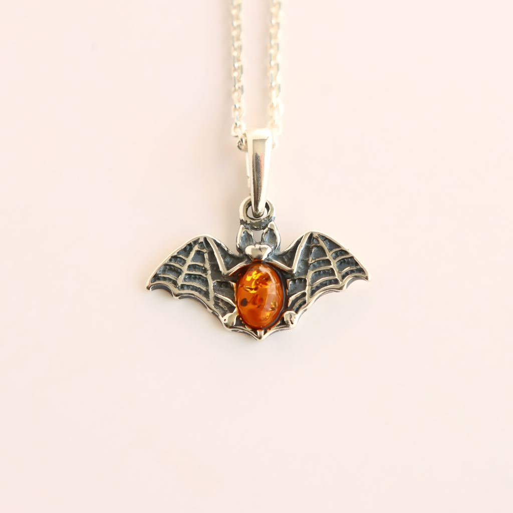 amber necklace with Silver bat pendant with amber stone on a white background