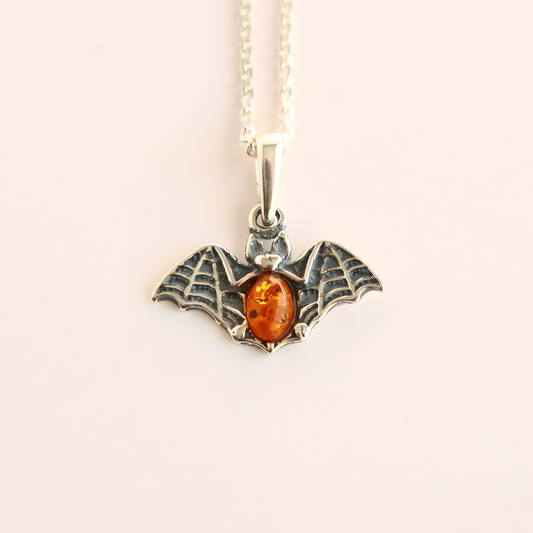 amber necklace with Silver bat pendant with amber stone on a white background