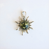 amber Sun pendant with a green gemstone on a white background