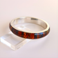 Bangle bracelet with mosaic amber design on a white background